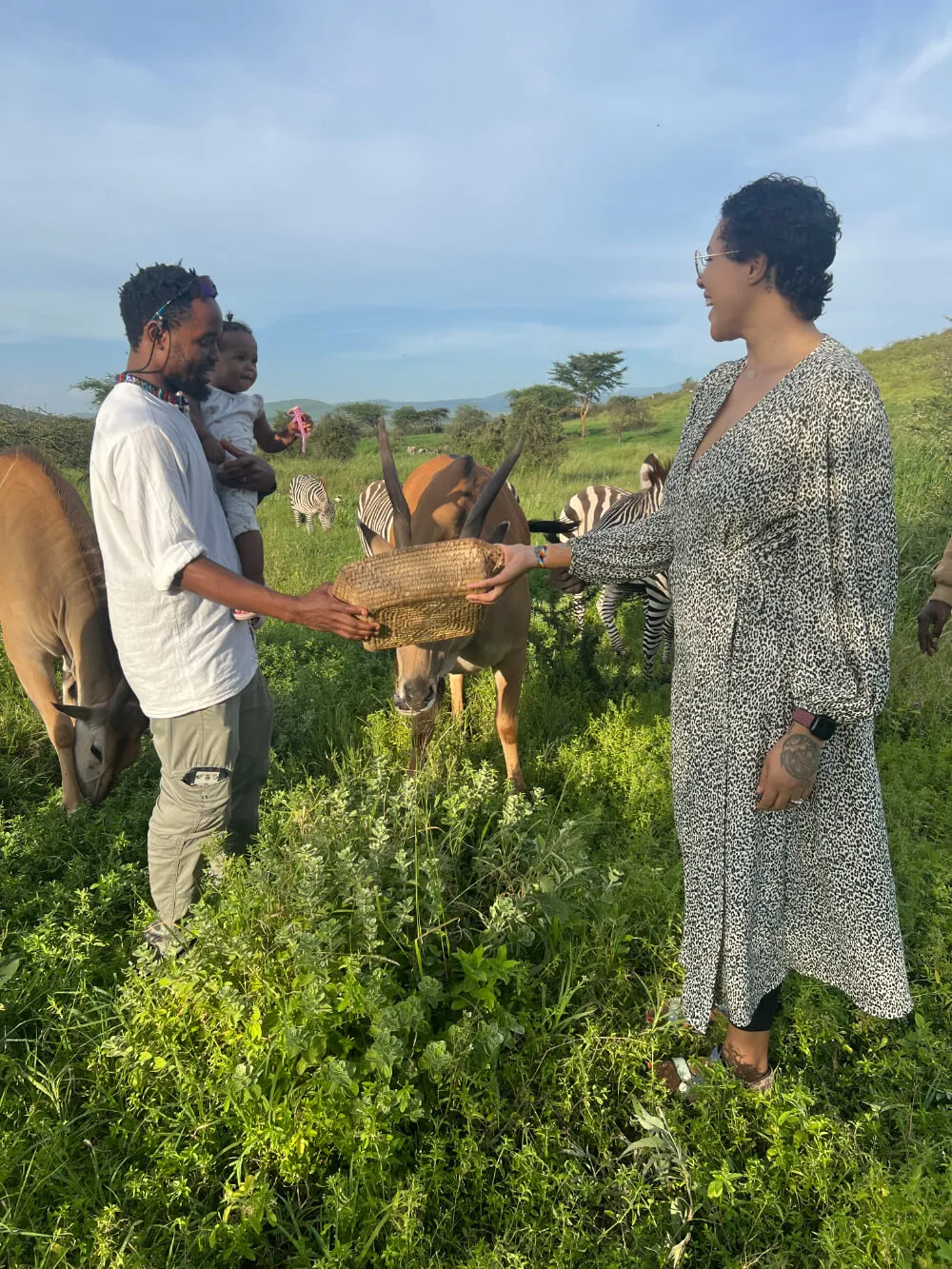 two adults and baby feeding an eland